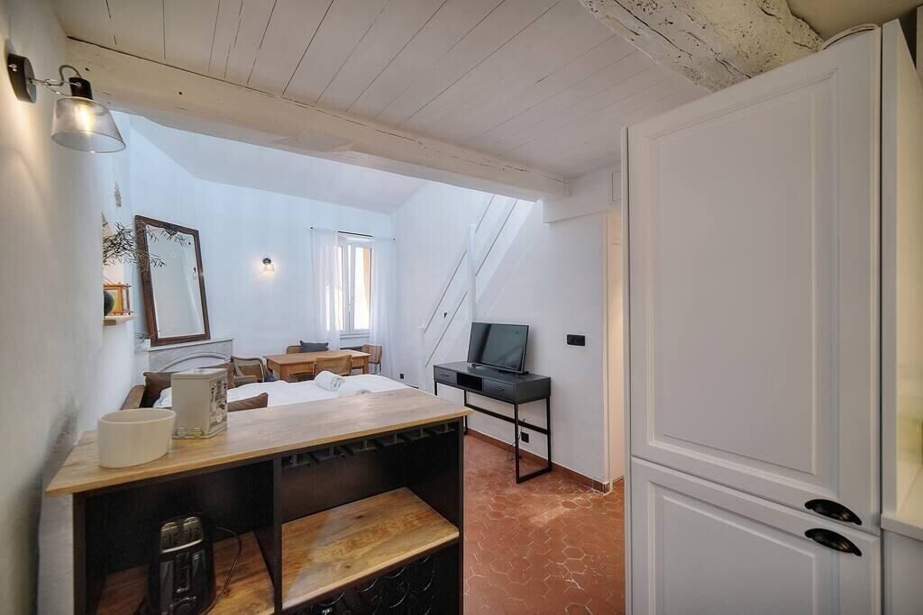 Una habitación pequeña con escritorio de madera, televisión y cama.