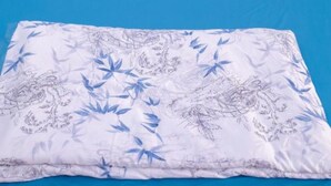 A bed with a blue mattress and white bedding with a leaf pattern. - Doi Thong Homestay (Ha Giang 1)
