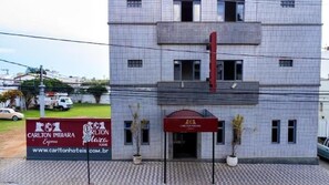 Ένα ξενοδοχείο με πρόσοψη επενδεδυμένη με πλακάκια, μια κόκκινη τέντα και μια επιγραφή που διαφημίζει το Carlton Imbira Express.