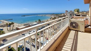 Un balcon avec vue sur une plage et la mer.