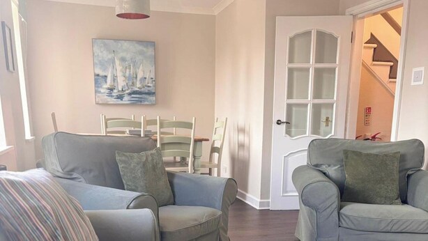 A living room with two grey sofas, a striped pillow, and a painting of sailboats. - Close to beach, town, golf & natural beauty spots (Montrose)