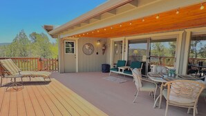 Une terrasse extérieure couverte, aménagée avec des chaises longues, une table à manger et des chaises.