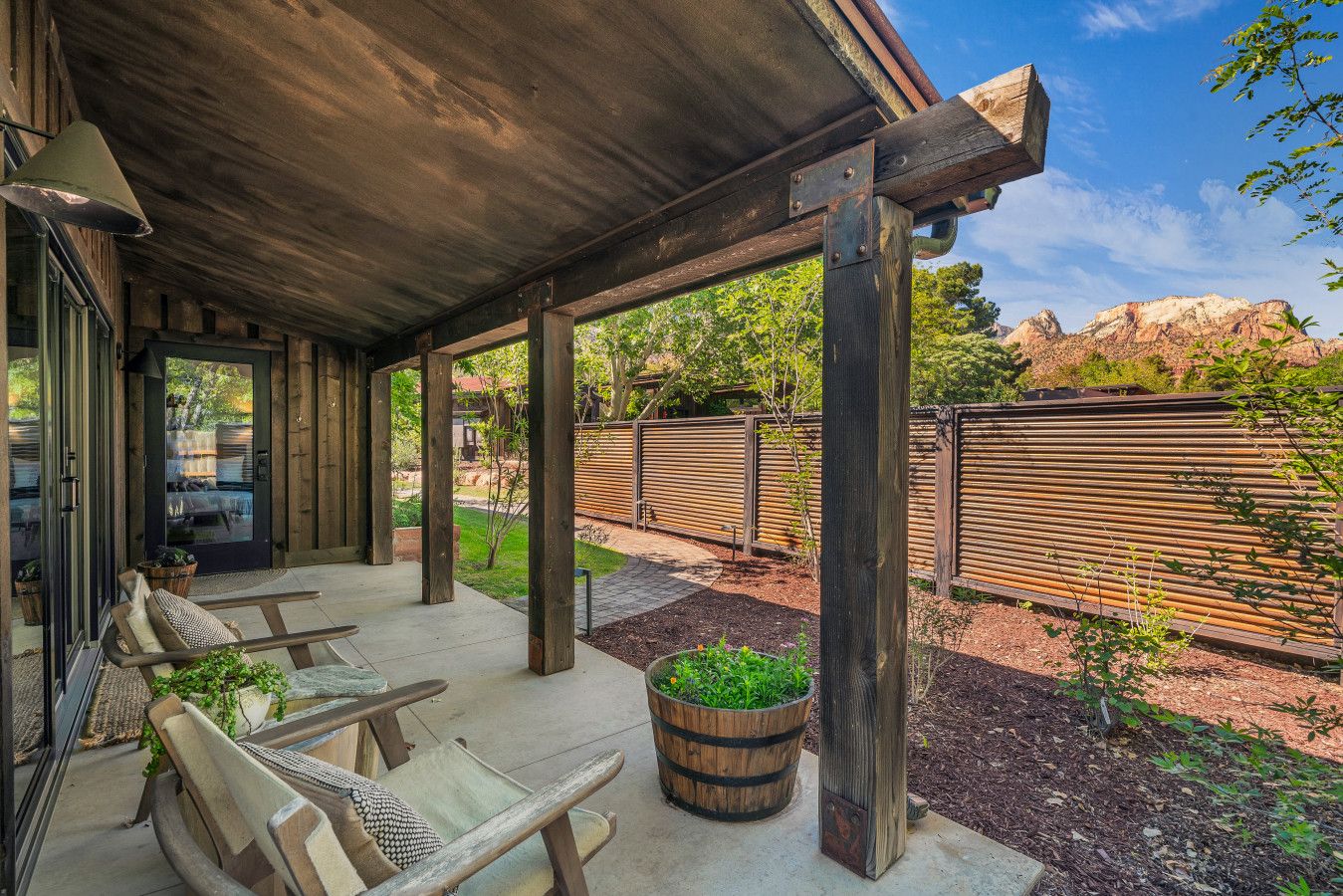 Eine überdachte Terrasse mit Holzmöbeln und Pflanzgefäßen.