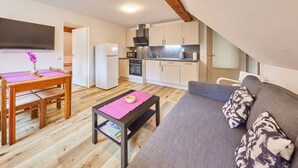 Un appartement compact comprenant une cuisine, un coin repas et un salon.