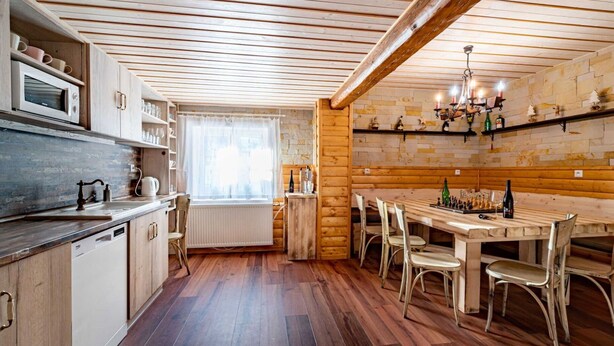 Une cuisine avec des meubles en bois, un four à micro-ondes et un coin repas comprenant une table et des chaises.