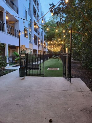 Secure entrance to a residential building with a small green space.