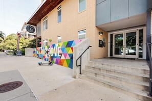 Rakennuksessa on värikäs, geometrisesti kuvioitu julkisivu ja kyltti, jossa lukee: ”120 Ninth Street”.