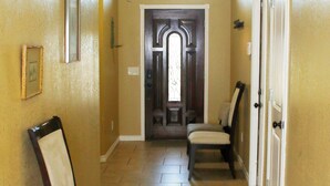 A hallway with two chairs, a door, and a window. - Efficient and Modern home, Sleeps 8. Theres an airmattress that sleeps 2. (Oklahoma City)