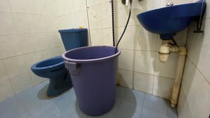 A bathroom with a blue toilet, a blue bucket, and a blue sink. - Hotel O Homestay Pak To Syariah (Surabaya)