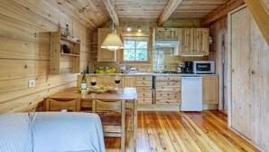 A wooden cabin interior with a dining area, kitchen, and a small refrigerator. - Mazot Mer de Glace near Chamonix w/ Private Garden, Deck & Views, Chamonix, France (Chamonix)