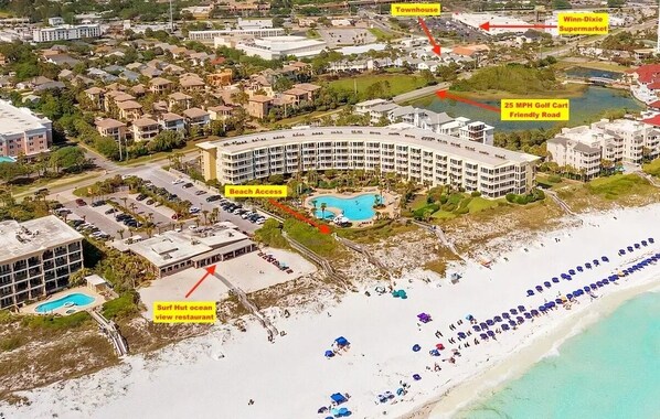 Un resort con piscina, acceso a la playa y restaurante con vista al océano, estilo choza de surf.