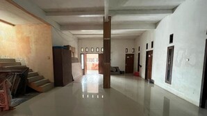 Un pasillo amplio y bien iluminado con piso pulido, que conduce a una habitación con cama y ventana.
