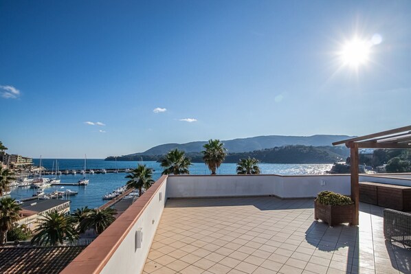 A terrace with a view of a marina and the sea.