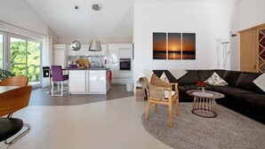 Un salon moderne comprenant un canapé, une table basse et un coin repas avec des chaises et une table.