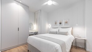 A bedroom with a bed, bedside table, nightstand, and a ceiling fan. - Phaedrus Living: Prosperity Residences Paradise (Athina)