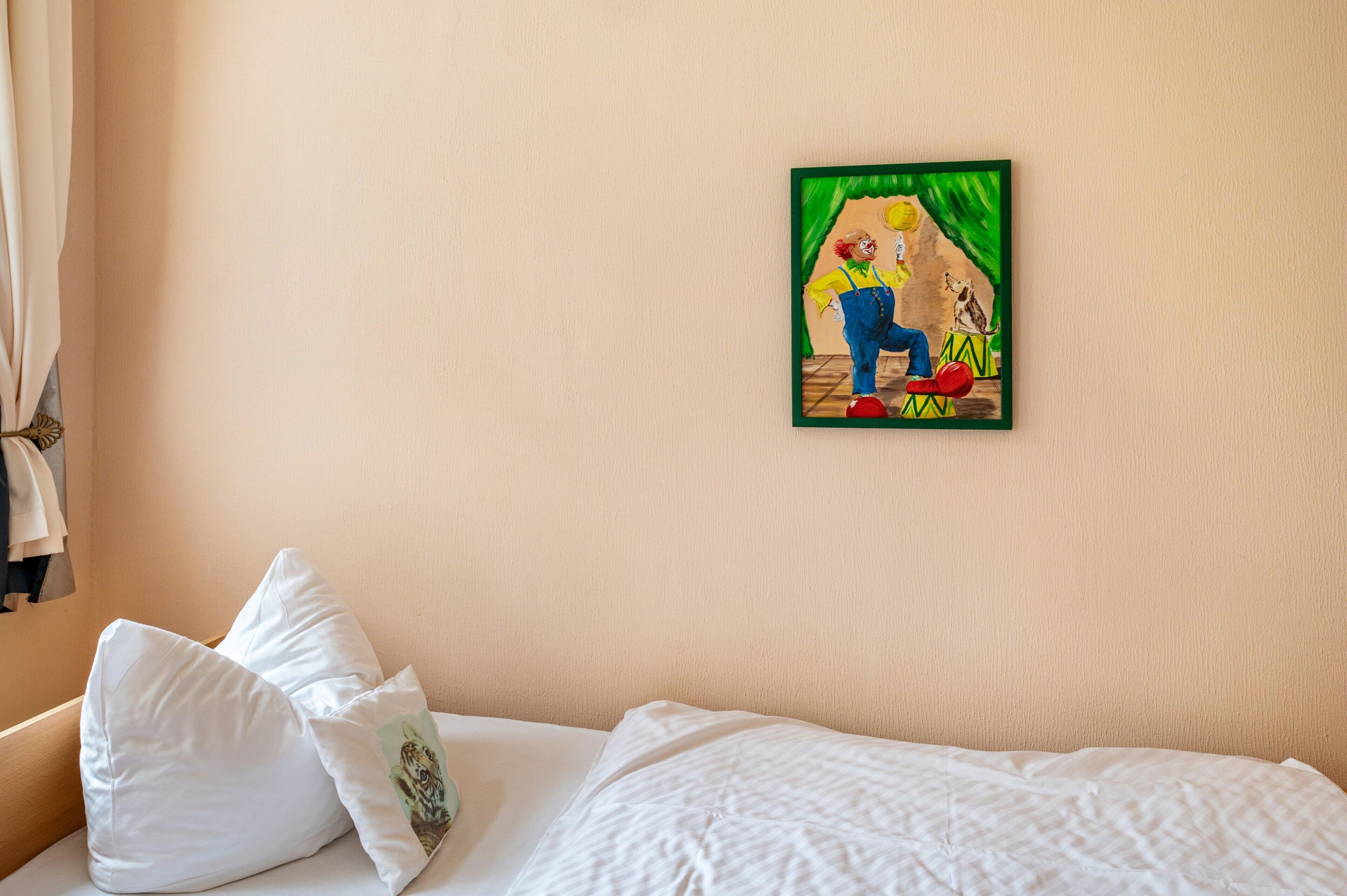 Ein Hotelzimmer mit Bett, Kissen und einem Wandbild.