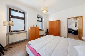 Une chambre à coucher avec un grand lit, une armoire en bois et un radiateur.