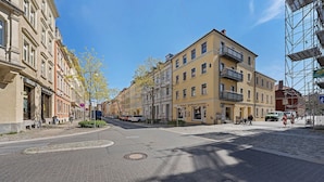 Una strada con edifici, una rotatoria e un attraversamento pedonale.
