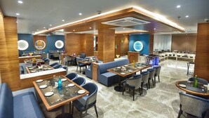 A modern restaurant with multiple dining areas, including booths and tables.
