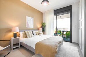 A modern hotel room with a large bed, two bedside tables with lamps, a framed artwork on the wall, and a balcony with outdoor furniture. - Modern Haven in South TLV by Sea N' Rent (Tel Aviv)