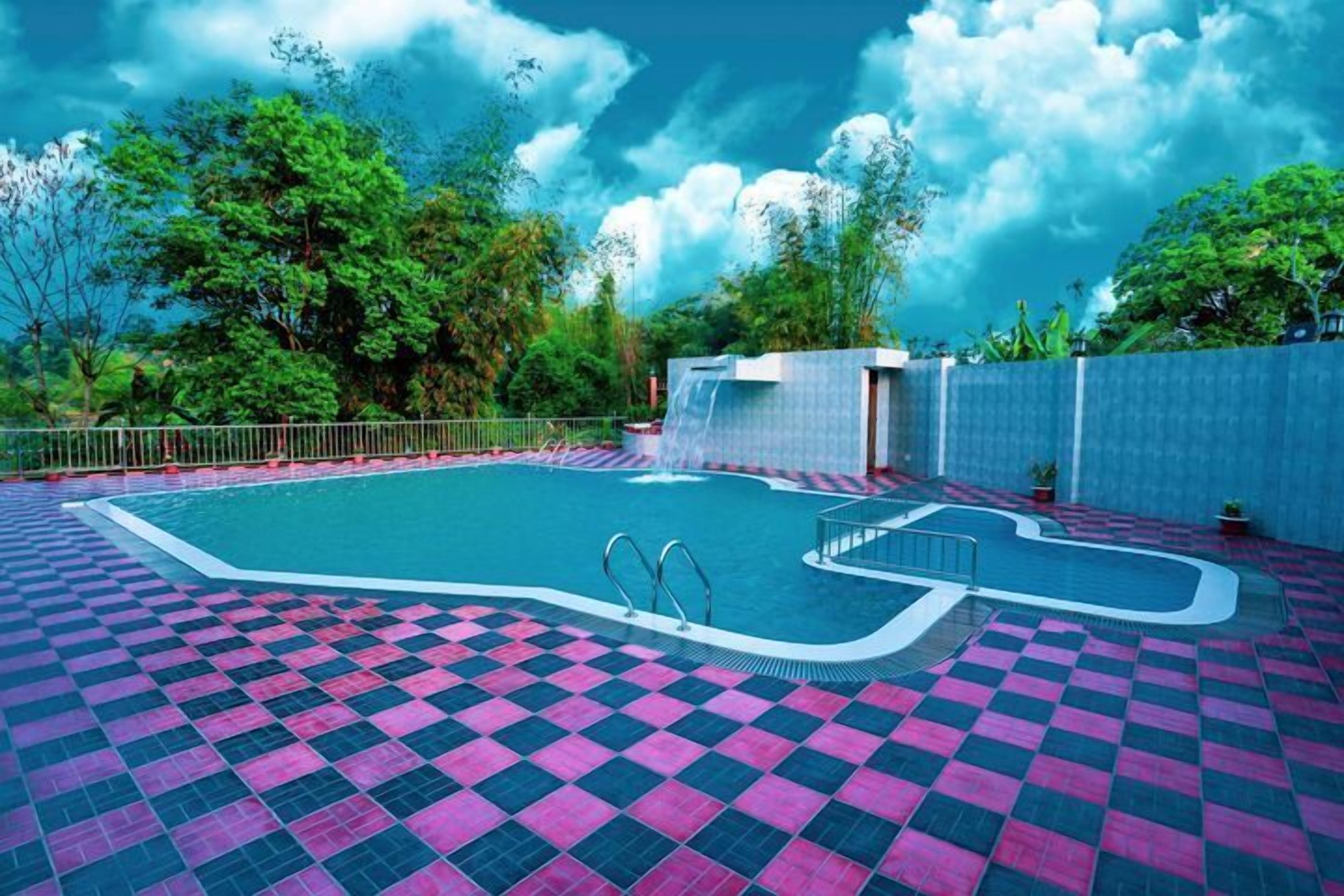 A swimming pool with a checkered floor, surrounded by a fence, and a waterfall feature.