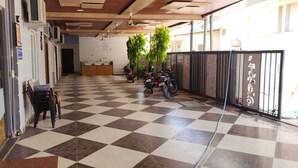 A reception area with a checkered floor, a reception desk, and several motorcycles parked near a gate. - Shree Keshav Haweli (Sikar)