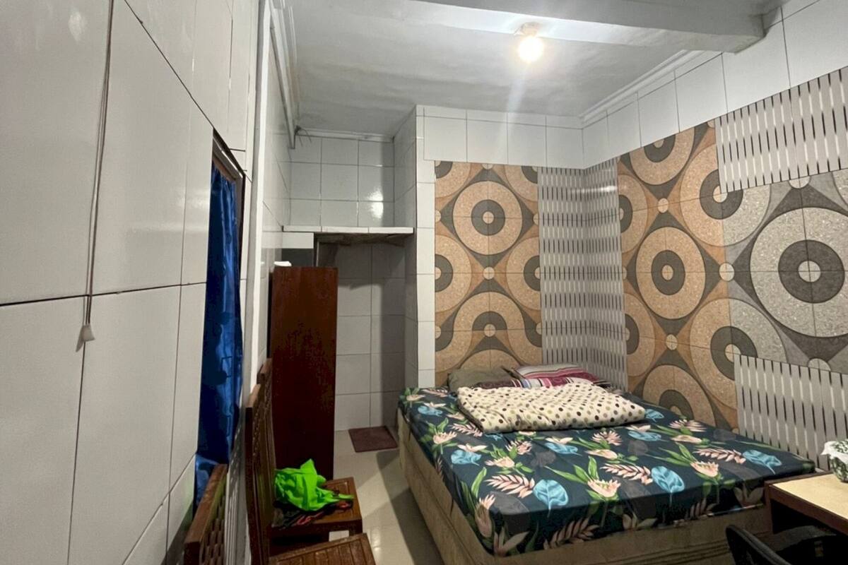 A bedroom with a bed, a desk, and a chair.