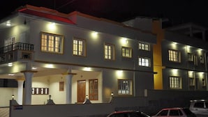 A multi-story residential building with a balcony, multiple windows, and a gated entrance. - Silver Spring Cottages (Ootacamund)