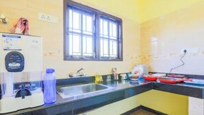 A kitchen with a sink, a window, and a water dispenser. - Silver Spring Cottages (Ootacamund)