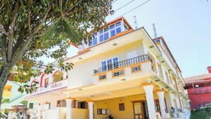A two-story building with a balcony on the upper floor, a covered entrance, and a checkered floor pattern. - Silver Spring Cottages (Ootacamund)