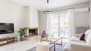 Un salon moderne avec une cheminée, un téléviseur, un canapé et une table à manger.