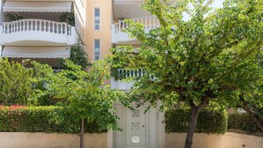 Un immeuble résidentiel à plusieurs étages, doté d’une façade beige, de balcons et d’une entrée sécurisée par un portail.