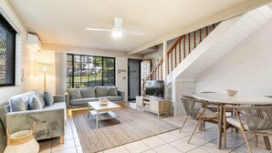 A modern living room with a sofa, coffee table, and dining area. - Pet-friendly 2 bedroom villa (Lennox Head)