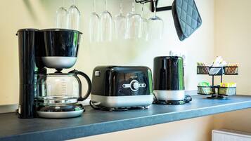 Eine Küchenarbeitsplatte mit Kaffeemaschine, Toaster und Wasserkocher.