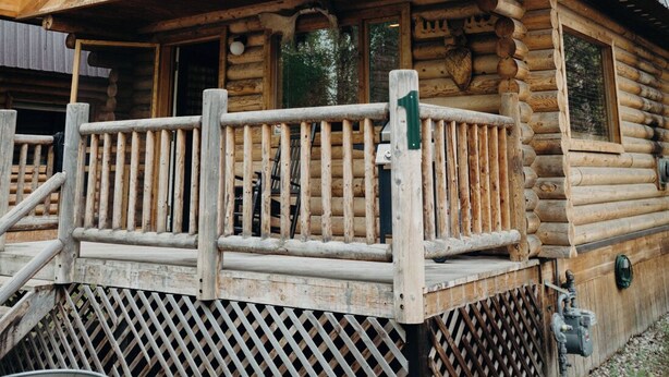 A log cabin with a wooden deck, a window, and a door. - Tranquil cabin with WiFi in charming Wasilla (Wasilla)
