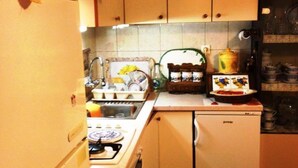 A compact kitchen with a refrigerator, stove, sink, and a small dishwasher. - Guest House Ruza (Dubrovnik)