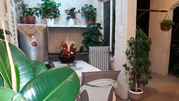 A small patio area with a table, chairs, and various potted plants. - Guest House Ruza (Dubrovnik)