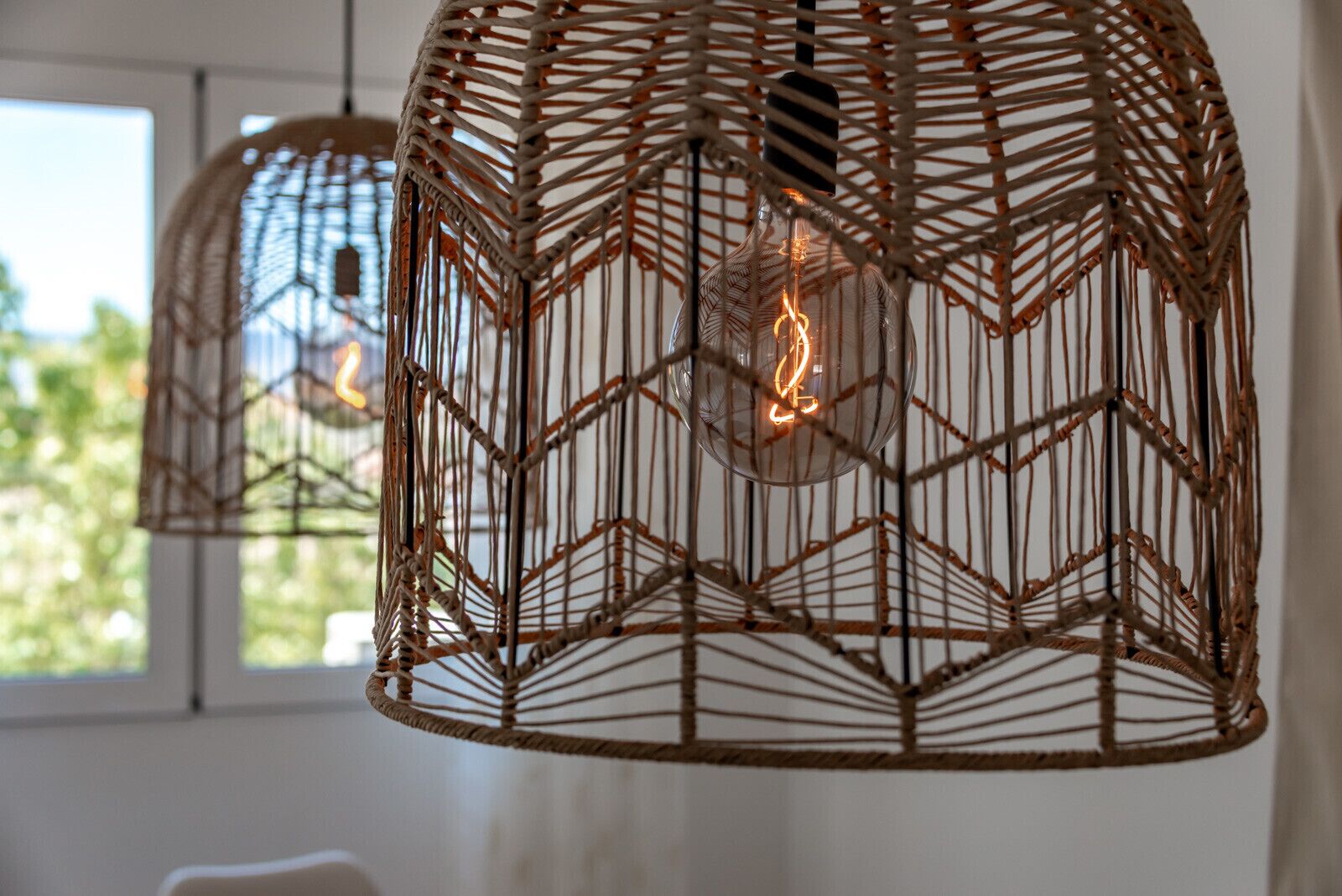 A hanging light fixture with a geometric wire design and visible filament bulbs.