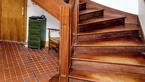 A wooden staircase with a green metal cabinet and a chair at the bottom. - Keravel, family home with character and direct access to the sea (Tréflez)