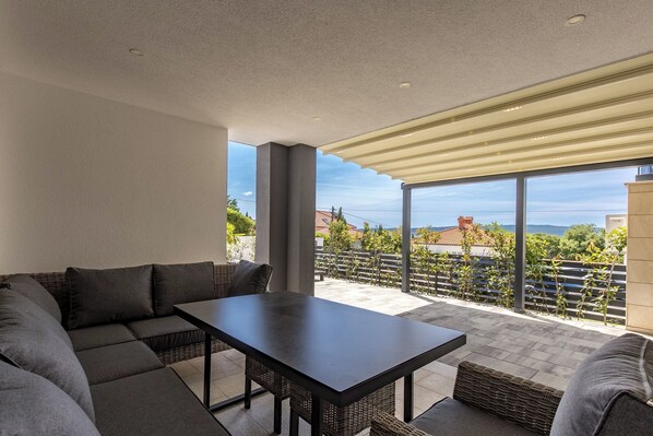 Relax and socialize in this serene outdoor space with a comfortable sofa and dining area.