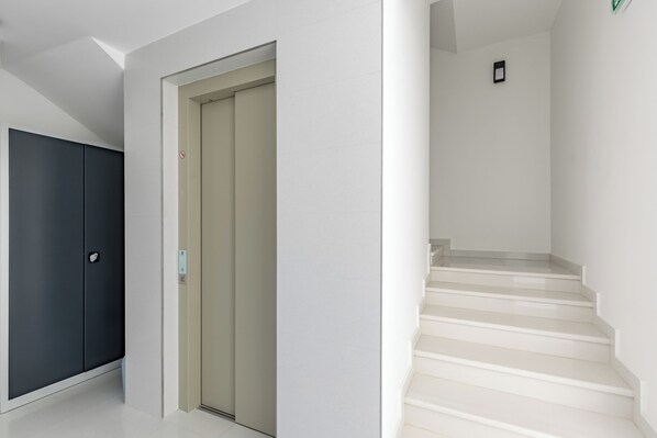 A hallway with a dark-colored wardrobe, a beige door, and a staircase leading to an upper floor. - Pool Apartments Crikvenica (Crikvenica)