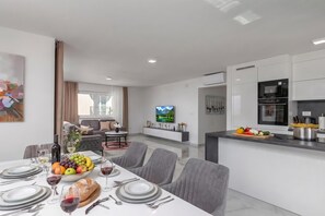 A modern apartment with a dining area, kitchen, and living space. - Pool Apartments Crikvenica (Crikvenica)