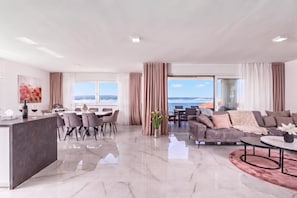 A spacious living area with a dining set, a sofa, and a view of the sea. - Pool Apartments Crikvenica (Crikvenica)