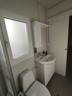A compact bathroom with a toilet, sink, and a window above the toilet. - Dalmatino Pleasure Mobile Home (Privlaka)