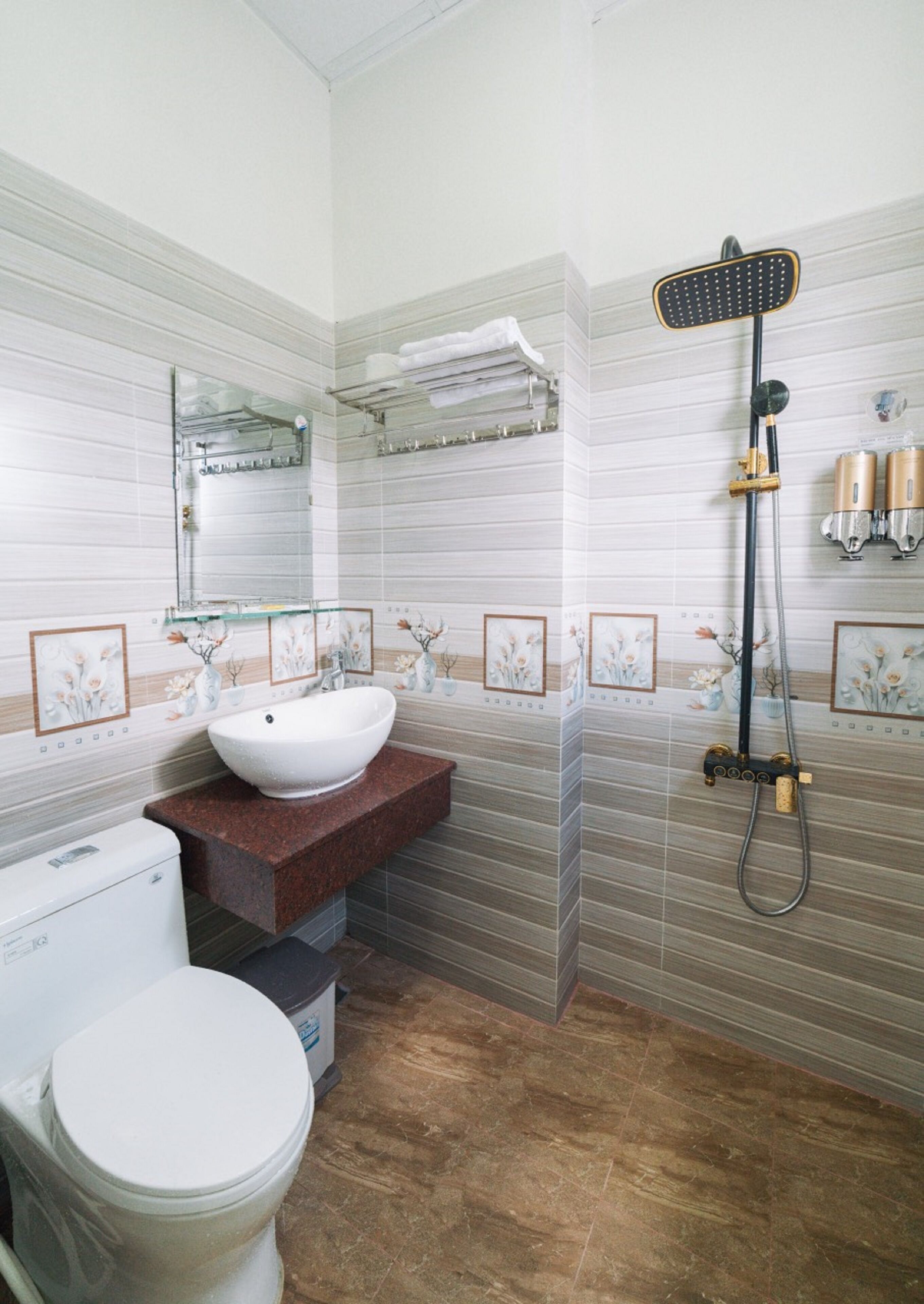 A bathroom with a white sink, a toilet, and a shower with a handheld showerhead.