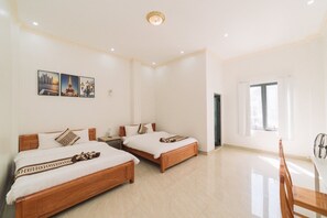 A hotel room with two wooden beds, a dining table, and a window. - Viet Anh Hotel Da Lat (Xuan Huong - Da Lat)