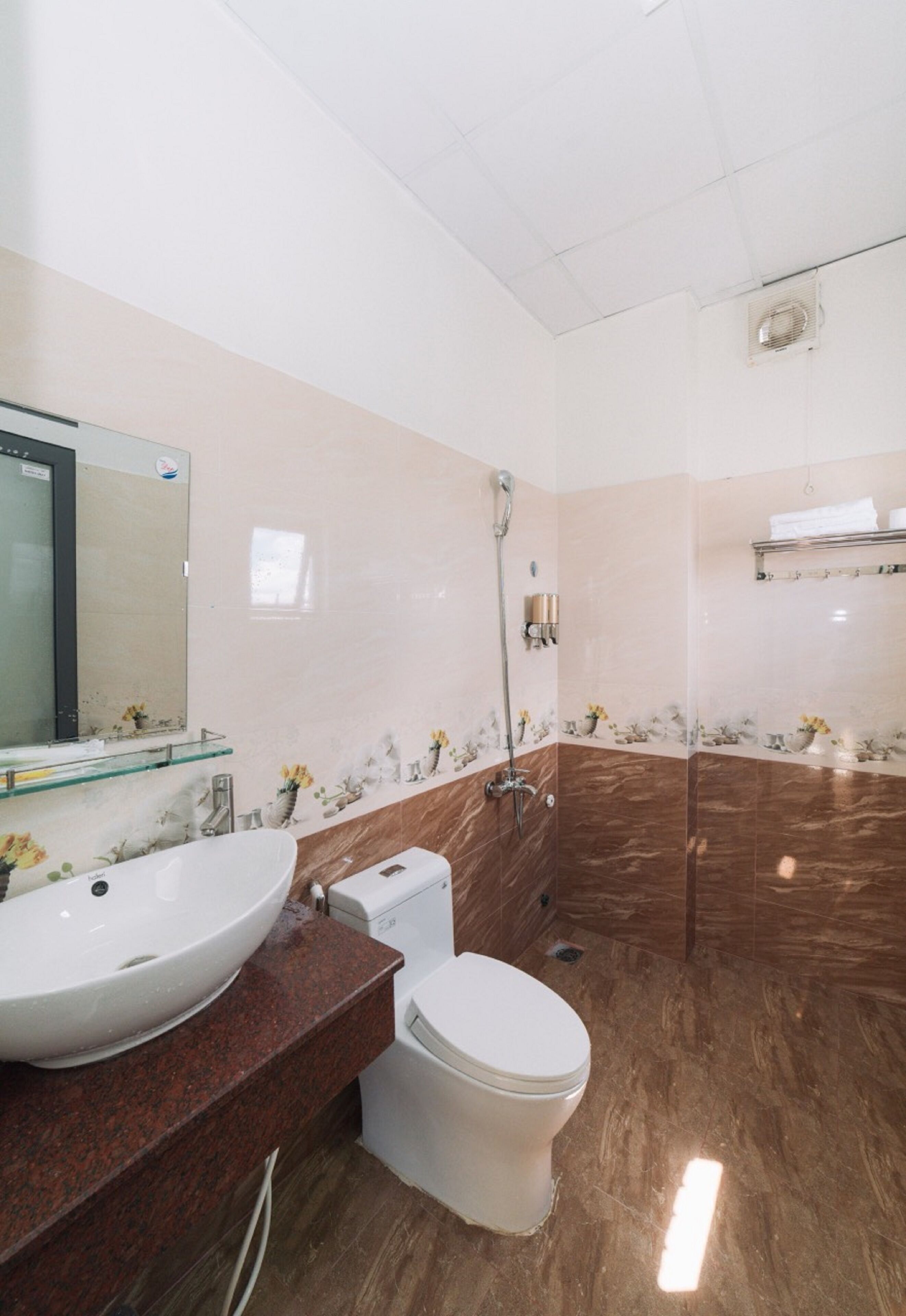 Ein Badezimmer mit einem großen Waschbecken, Toilette und Dusche.