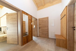 A modern interior with wooden doors, a bench, and a small table.