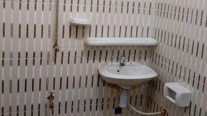 Et badeværelse med tapet, et håndvask og et toilet.