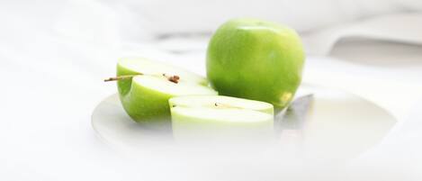 A green apple on a white plate.